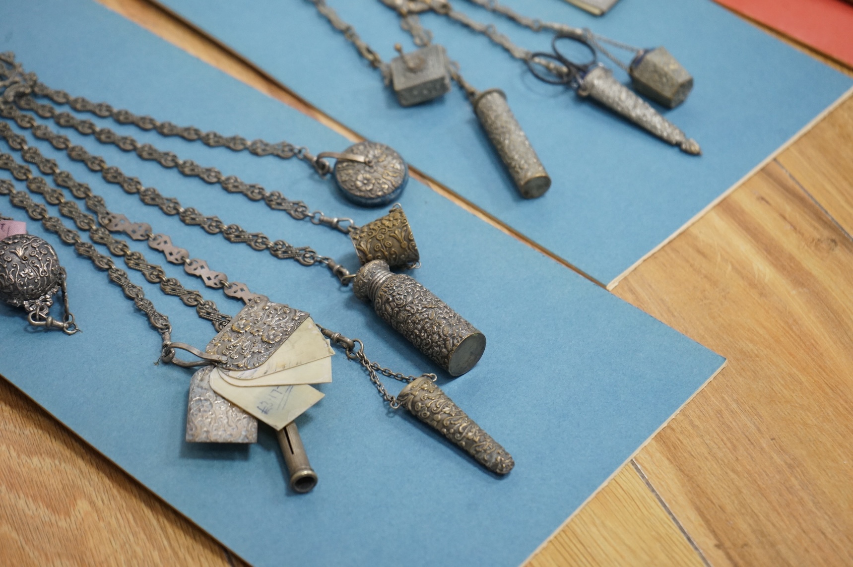Four assorted 19th century base metal chatelaines, one with some silver implements